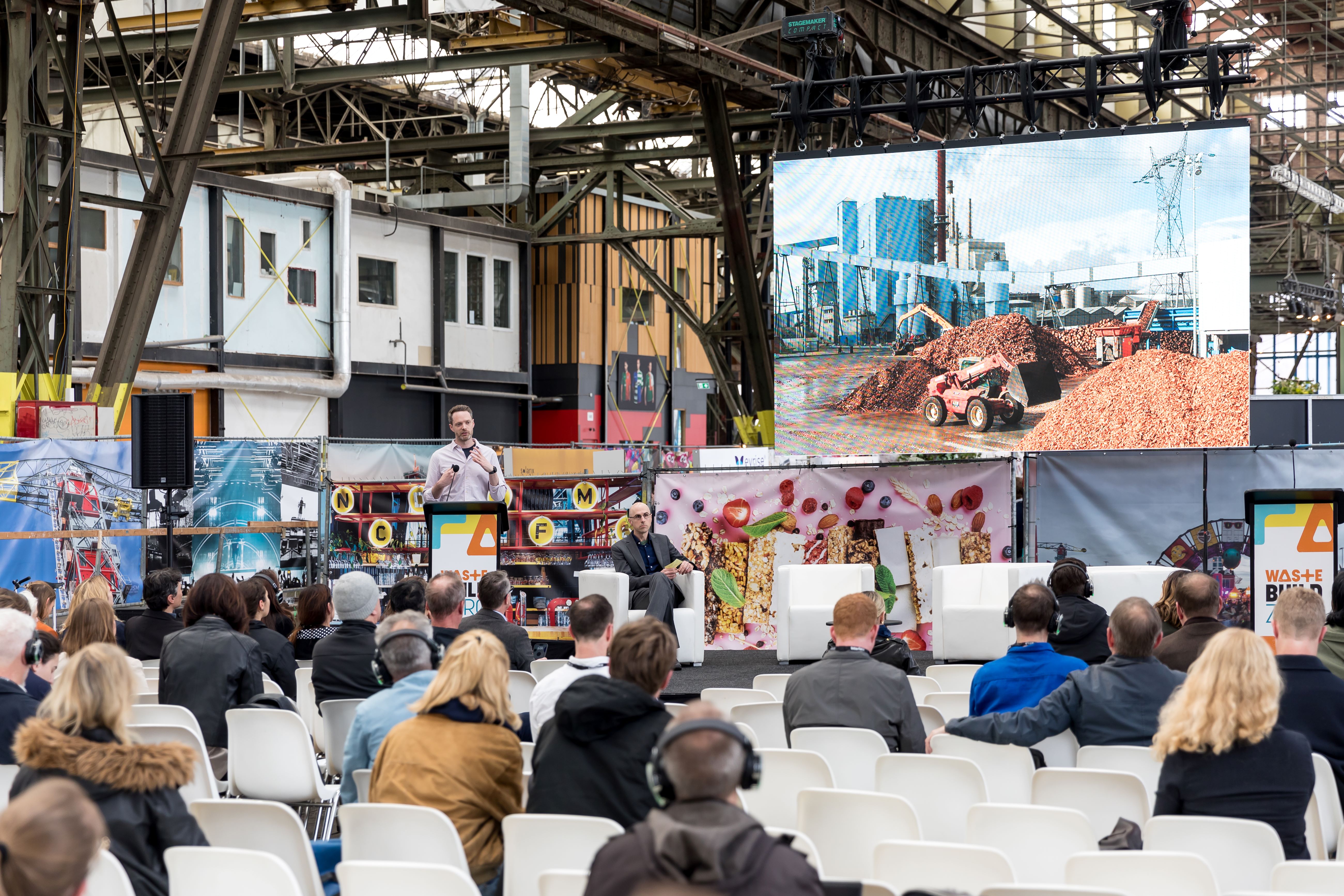 Founder of Regenerative Works Philip Isaac presenting at the Wastebuild Awards on reusing waste timber and upcycling into new glue-laminated sections.